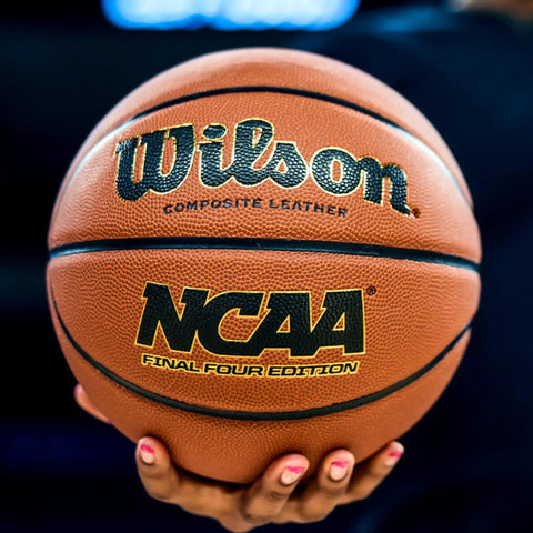 Hand holding NCAA Final Four Edition Basketball Official Size 29.5 Inch With High Definition Pebble Grip Deep Channel Construction