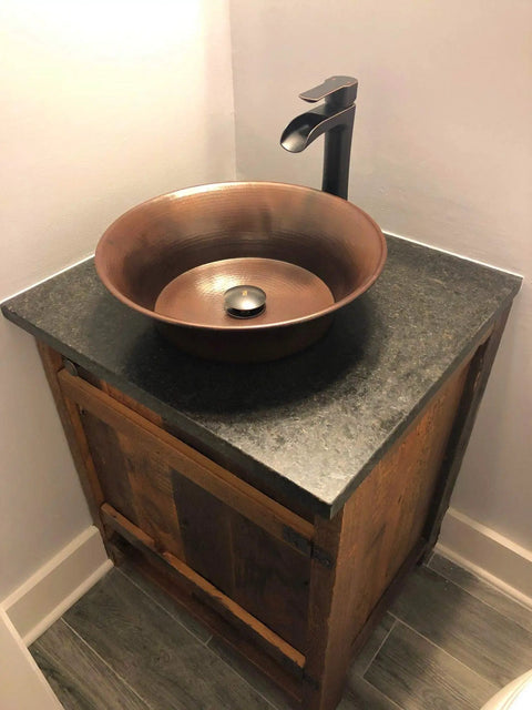 Bathroom setup with Copernicus Handmade Vessel Sink In Pure Solid Copper, 16 Inch, Aged Copper Finish on wood cabinet.