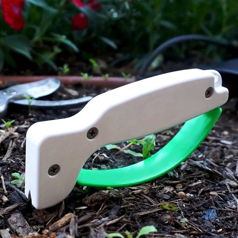 Portable Handheld Knife Sharpener With V Notch Edge Restorer for garden tools on soil background