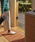Person holding Move 2 Black Portable Bluetooth Speaker with dual tweeters in indoor setting by door leading to outdoor patio.