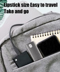 Gray travel bag pocket with compact electronic accessories including power bank, smartphone, notebook, and charging cable.