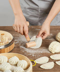 Real Deal 10 Inch Bamboo Steamer Basket Set With Dome Lid Stainless Steel Ring Adapter Dough Roller Press Tools For No Sweat Homemade Dim Sum Buns with rolling dough and dumplings.