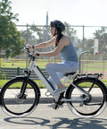 Person biking on a white bicycle with Two Pack 27.5 Inch Self Sealing Bicycle Inner Tubes with AV32mm Schrader Valve on a sunny day.