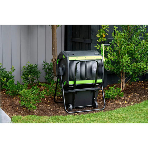Dual Chamber 48 Gallon Compost Tumbler With Geared Rotation And Cart Access in yard for easy turning of kitchen scraps
