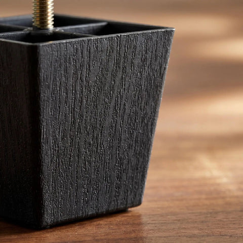 Close-up of black plastic and metal adjustable leg from 8-Piece Square Sofa Legs With Threaded Studs For Cabinets And Benches.