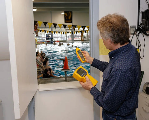Person using Top Dollar Digital Dual Panel Temperature Humidity Meter With No Sweat Dew Point Tracking at a swimming pool.