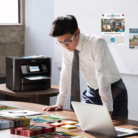 Man working near WorkForce Pro WF 4830 Wireless All In One Printer No Fuss Auto Duplex Printing With Copy Scan Fax 50 Page ADF 500 Sheet Tray 4.3 Inch Color Touchscreen Alexa Compatible Black.