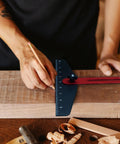 Person using Adjustable Stair Tread Template Angle Finder with heavy duty aluminum frame on wood for precise markings.