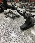 Plug-And-Play Handlebar Mounted Bike Repair Stands Pair, black, on a bike handlebar, 25kg load, fits 30-35mm handlebars on table.