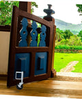 Heavy Duty Spring Loaded Gate Caster Wheel for Fences and Gates on a wooden gate, designed for smooth rolling over grass.