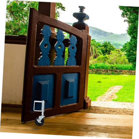 Heavy Duty Spring Loaded Gate Caster Wheel for Fences and Gates on a wooden gate, designed for smooth rolling over grass.