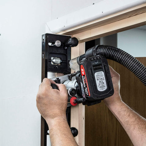 All-In-One Adjustable Door Hinge Jig Installation Kit For 2 Ft 6 In To 9 Ft Doors being used on a door frame with a router