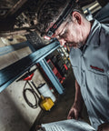 Mechanic wearing Dual Light Source USB Headlamp Twin Task 375 Lumen Hands Free Night Work Light With Tilt Head in garage