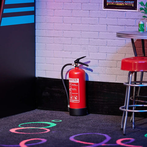 Rad Miniature Resin Fire Extinguisher 1/4 Scale Replica next to a barstool in an arcade room diorama setup.