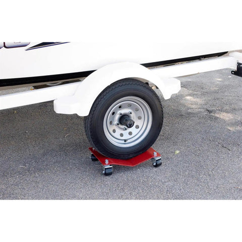 Ultra Slick Auto Dollies For Moving Vehicles under a trailer tire, showcasing the red steel frame and heavy-duty casters.