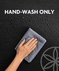 Hand washing a grey cloth on the textured surface of a Killer 10mm Thick Yoga Mat With Big Time Cushioning Plush NBR Foam.