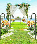 62 Inch Outdoor Shepherds Hook With 5 Prong Base set up in a garden, holding floral arrangements along a wedding aisle with arch in background