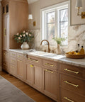 Modern kitchen with 20 Pack Built Tough Brushed Brass Gold Kitchen Cabinet Pulls on wooden cabinets next to marble countertop.