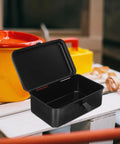 Small Iron Toolbox Featuring A Snug Metal Clasp For Portable Hand Carry Home Projects And Road Trip Trunk Organization open on a workbench.