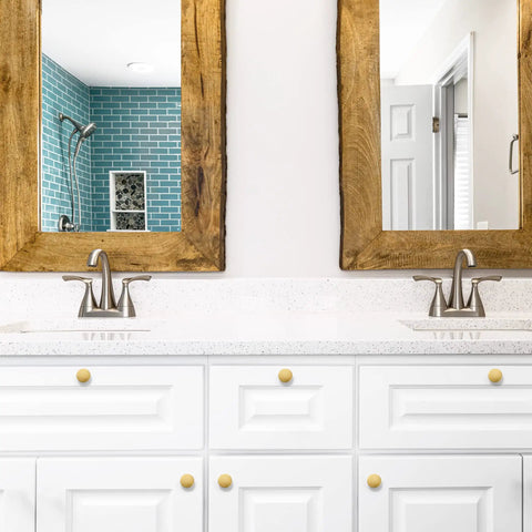 Level Up Your Kitchen Setup With This 25 Pack Of Heavy Duty Brushed Brass Cabinet Knobs Measuring 1-1/4 Inch Round Circle For A Sophisticated Vibe And Real Nice Upgrade To Any Drawer Or Vanity Project, shown on a white vanity with mirrors.