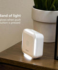 Wireless Security Doorbell Kit With Realistic Decoy Cam And Motion Activated Light, white unit on brown table.