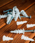 Heavy Duty Drywall Anchors Kit, 300-Piece Plastic Anchors With Spiral Expansion Tubes scattered on wooden surface