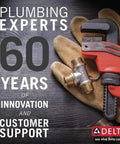 Red pipe wrench and valve with gloves on a wooden surface, celebrating 60 years of Delta's plumbing expertise and support