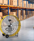 Beast 13000 CFM High Velocity Drum Fan With 2 Speed Heavy Duty Industrial Shop Air Circulator in warehouse setting, yellow.
