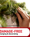 Hand using Clear Medium Wall Hooks Set with 7 Hooks and 12 Adhesive Strips for damage-free hanging on decorated wall