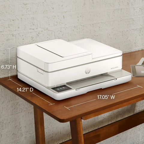 Side view of Envy 6555e Wireless All-In-One Color Inkjet Printer With Duplex Printing on a wooden table, dimensions visible.