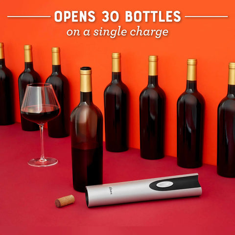 Cordless Electric Wine Opener With Automatic Cork Extractor And Precision Foil Cutter With Rechargeable Base Delivers Smooth Operation And Quick Releases For Zero Sweat Entertaining next to wine bottles and glass.