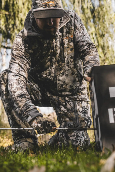 Camouflaged archer setting up 3D Archery Target 48 Inch Tall With Replaceable Insert For Long Life outdoors
