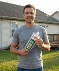 Man holding Fast Curing Construction Adhesive For Concrete, Brick, Stone And Granite With Extra Nozzle Included outdoors.