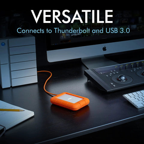 Rugged USB C 4TB Portable External Drive With Drop, Shock, Dust And Rain Resistance for Mac and PC on a desktop setup with accessories