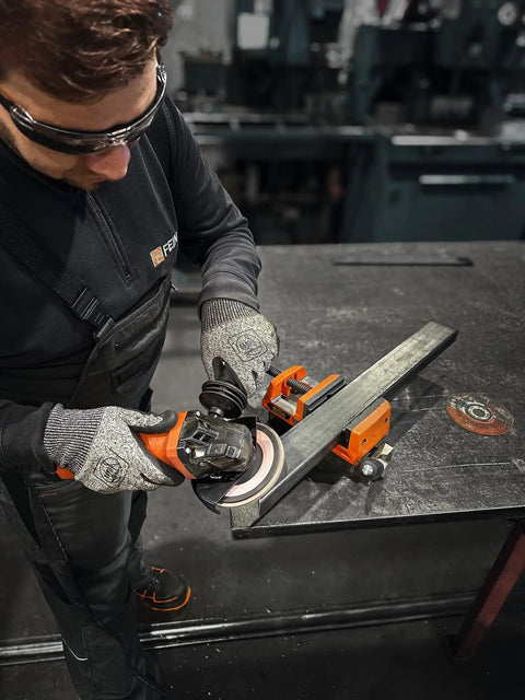 User operating the Top Shelf 1400 Watt Angle Grinder Packs Knock Tough 125mm cutting muscle on metal workpiece.