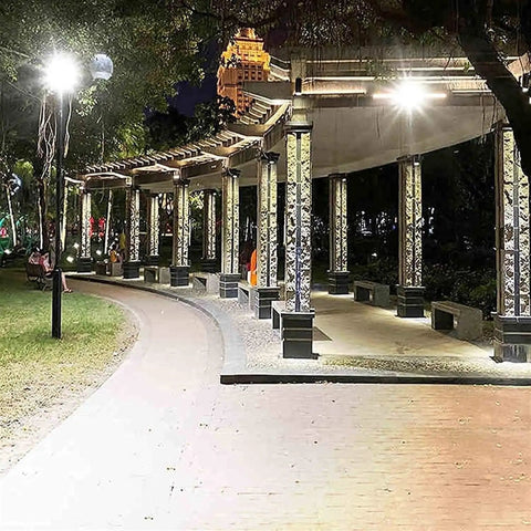 Top Tier Solar Led Flood Light With Remote Trigger And Smart Motion Detector For Driveway And Fence illuminating a curved pathway at night.