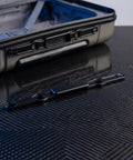 Rock Solid Luggage Pull Handle Replacement Button For Telescopic Suitcases on a black surface beside a suitcase.