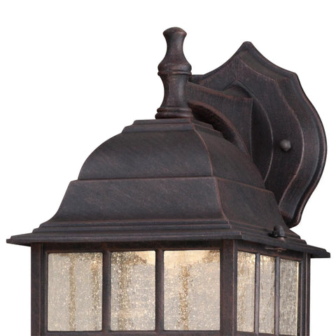 Solid Exterior Wall Lantern Featuring Slick Weathered Patina Cast Aluminum Body Plus Crisp Seeded Glass Panes close-up view with ornate top detailing.