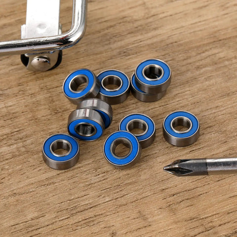 10-Pack MR115-2RS Miniature Deep Groove Ball Bearings Featuring Double Rubber Seals And Chrome Steel Construction with blue seals on wooden surface.