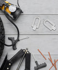 Three-Piece Dent Puller Ring Kit for Auto Body and Sheet Metal Repair, aluminum rings next to tire and tools on grey surface