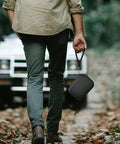 Heavy Duty Travel Organizing Bag And Cord Keeper For MagGo Three In One Charging Hub, carried in hand on a path.