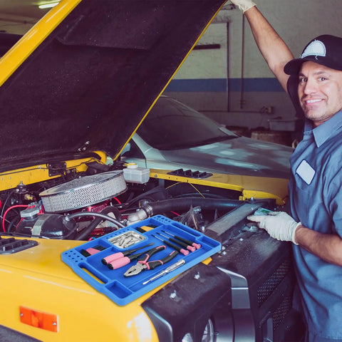 Mechanic using Blue Silicone Tool Tray For Auto Repairs Flexible Magnetic Tool Holder With Small Parts Tray on yellow vehicle