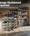 Freakishly Durable Industrial Grade Steel Knocks Out Clutter With A Badass 4 Tier Skateboard Rack Floor Stand For Garage Bedroom Display Holds Longboards Cruisers Skis Boots And Snowboards in a garage setting with tools.