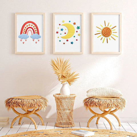 Wall with three framed rainbow, moon, and sun boho patterns from Five Piece Starter Embroidery Kit For Beginners With Boho Cross Stitch Patterns.