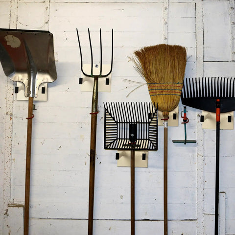 Real Deal Steel Shovel Holder Wall Mount 2 Pack With Extended Tines holding shovels, rakes, and brooms on a garage wall.
