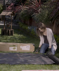 Person installing Pro Grade 5oz Landscape Fabric Weed Barrier Mat 3 Feet By 50 Feet Heavy Duty Ground Cover in garden
