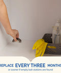 Person placing Fast Acting Liquid Roach Bait 6 Pack bait station inside kitchen cabinet for pest control.