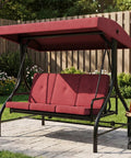 Three Seat Outdoor Porch Swing With Stand 2 In 1 Convertible Lounger Bed Stepless Adjustable UV Resistant Waterproof Canopy Cushioned Patio Swing for Garden Or Backyard 800 Lb Capacity in red color on patio with plants in background.