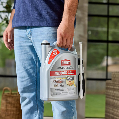 Indoor Insect Killer Spray With Wand Builds A Tough Shield Against Roaches, Ants, Spiders, Ticks And Fleas Ready To Use Crackdown On Household Pests 1 Gallon held by a person in a casual setting.