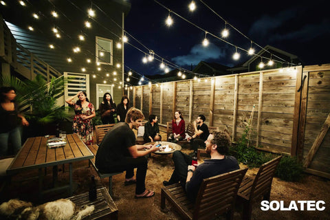 Shatterproof LED String Lights 48Ft Outdoor Commercial Grade Waterproof With 15 Hanging Sockets above patio with people gathered.